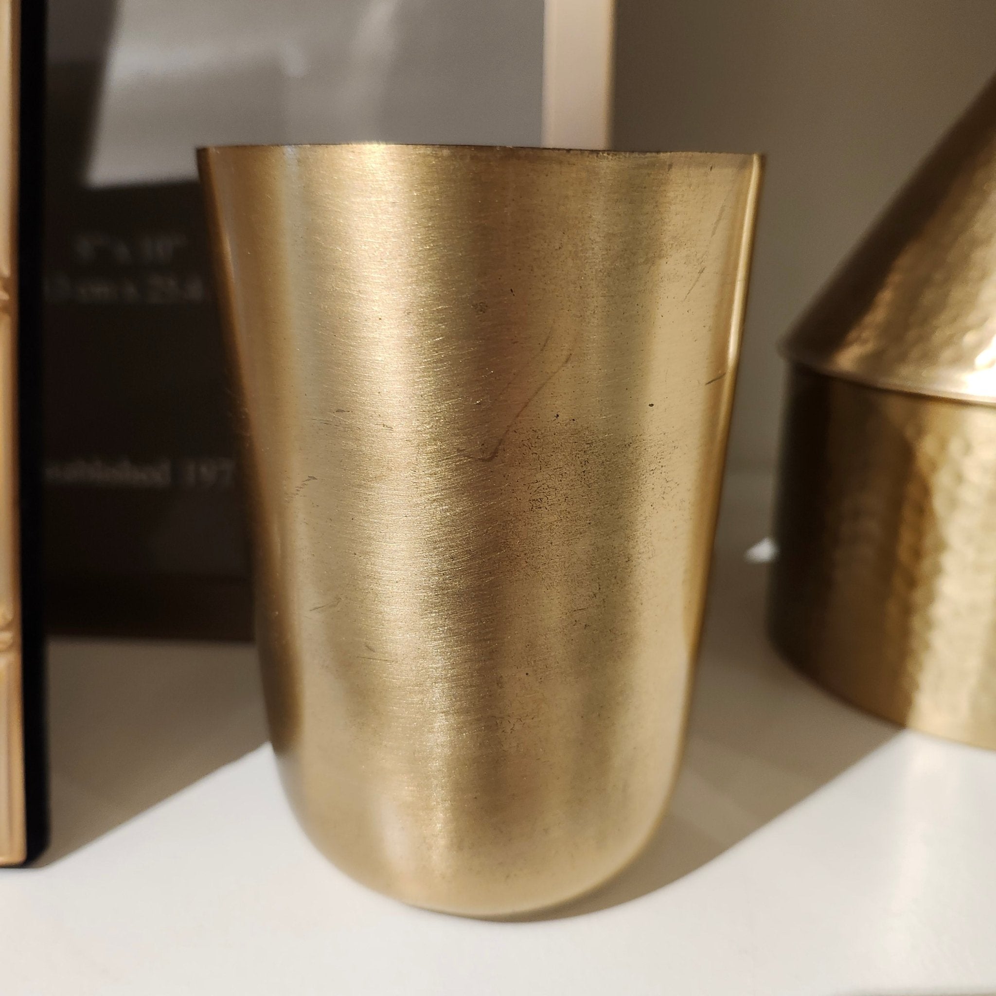 Solid brass tumbler shown from a second angle, 10cm high by 7cm wide, golden brass finish