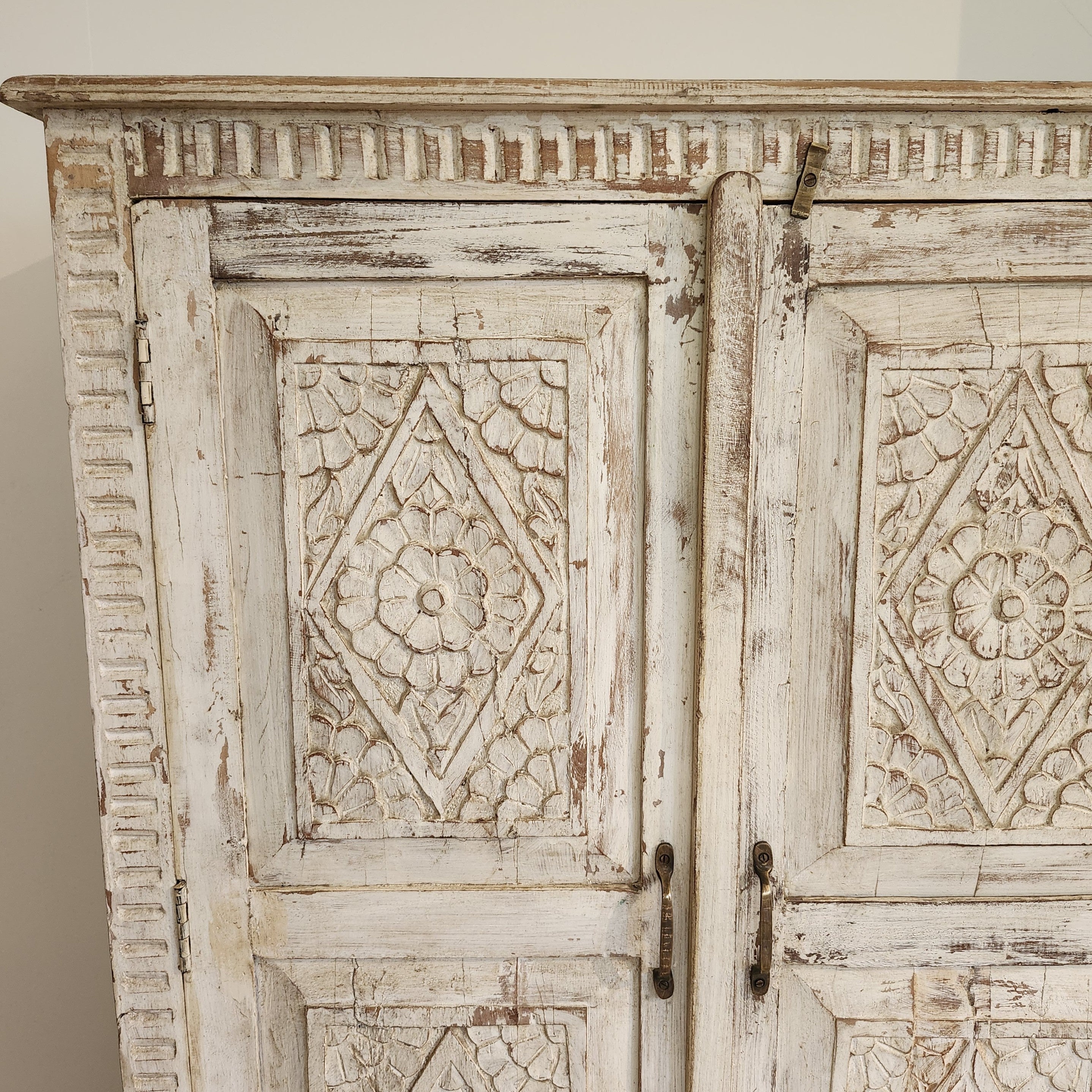 Hand-carved mango wood cupboard with a whitewash finish and floral panels