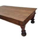 Long vintage teak coffee table from India, 176cm wide and 83cm deep, shown from another angle with its red and green legs