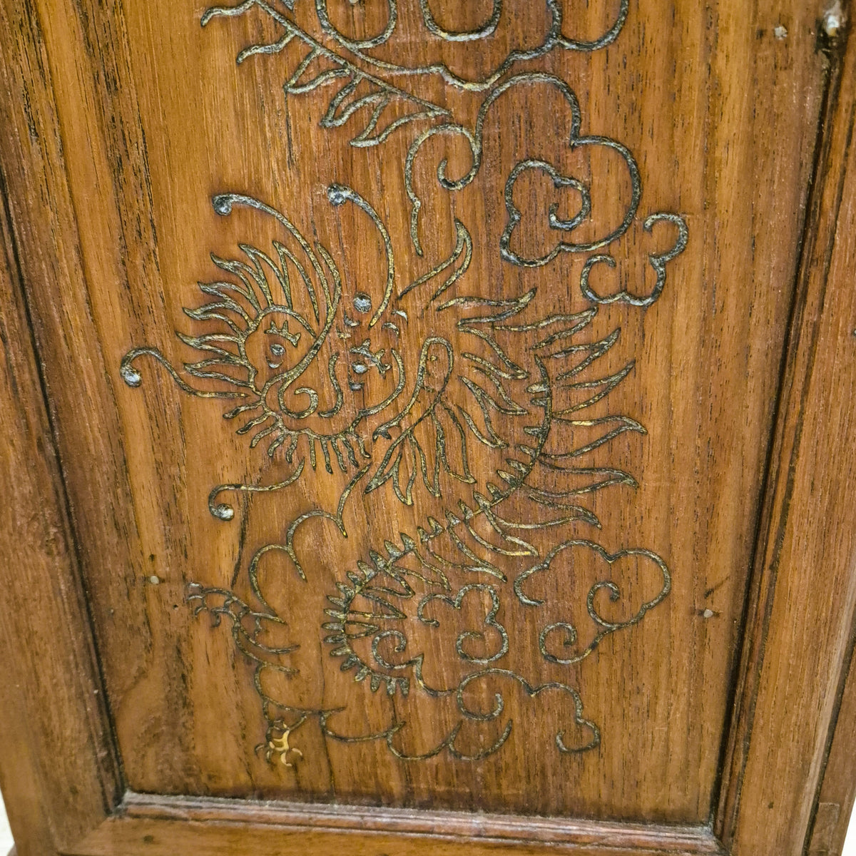 Carved dragon detail on a small vintage teak side table, with a shelf inside the cupboard underneath