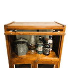 Detail of the glass fronted doors on a small vintage teak drinks cabinet in natural wax, 129cm high, 65cm wide, from India