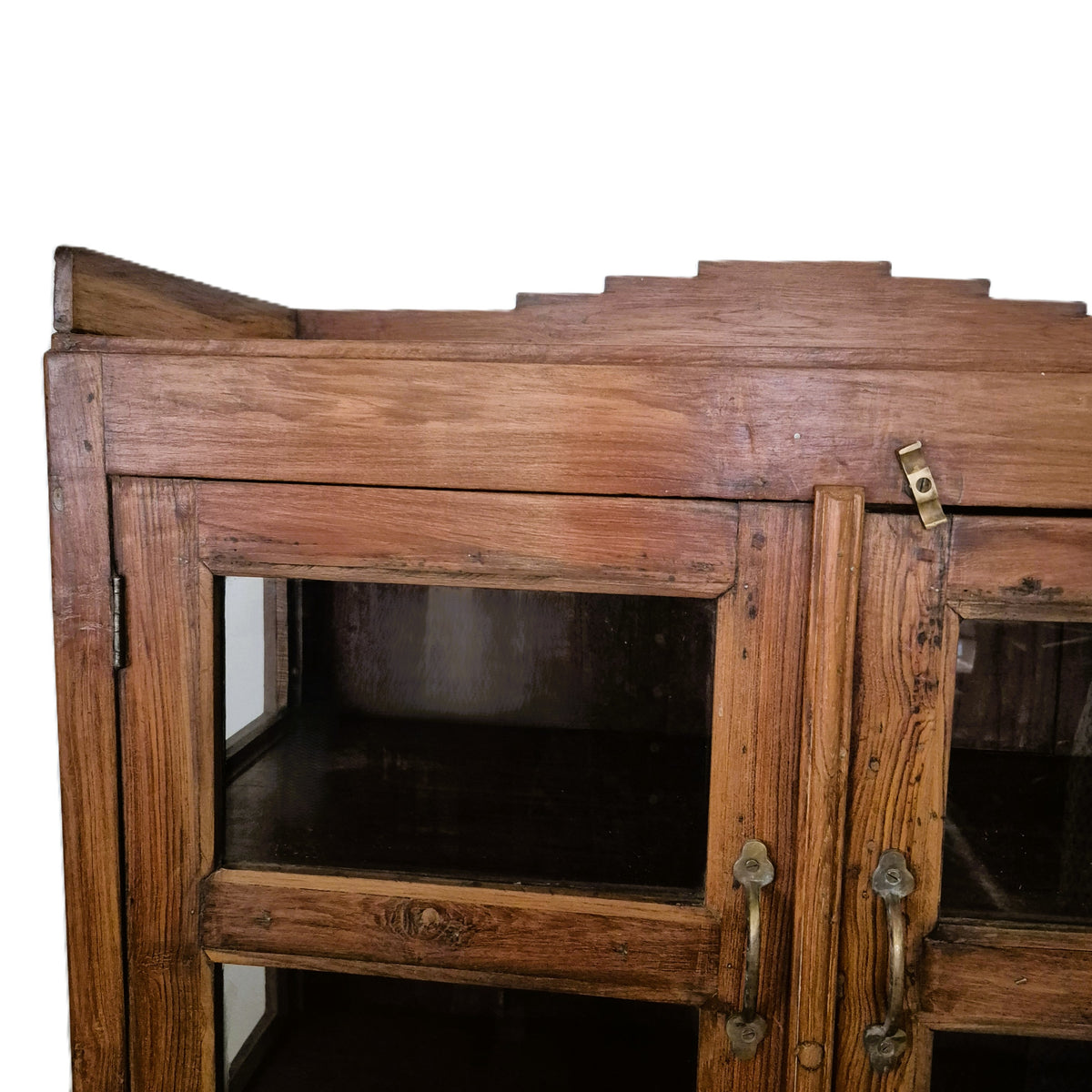 Teak cabinet with angular art deco carving on the top shelf and brass and wood handles, 87 cm in width