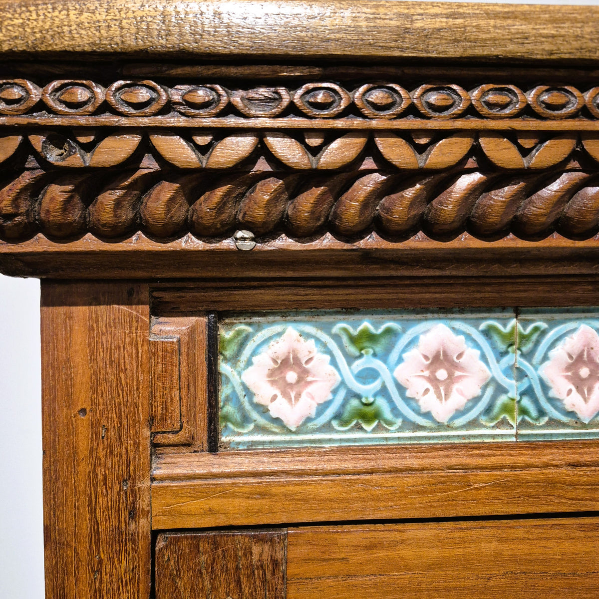 Line of tiles set above the sunburst carving on a two door vintage teak cabinet made in India, 158 cm high