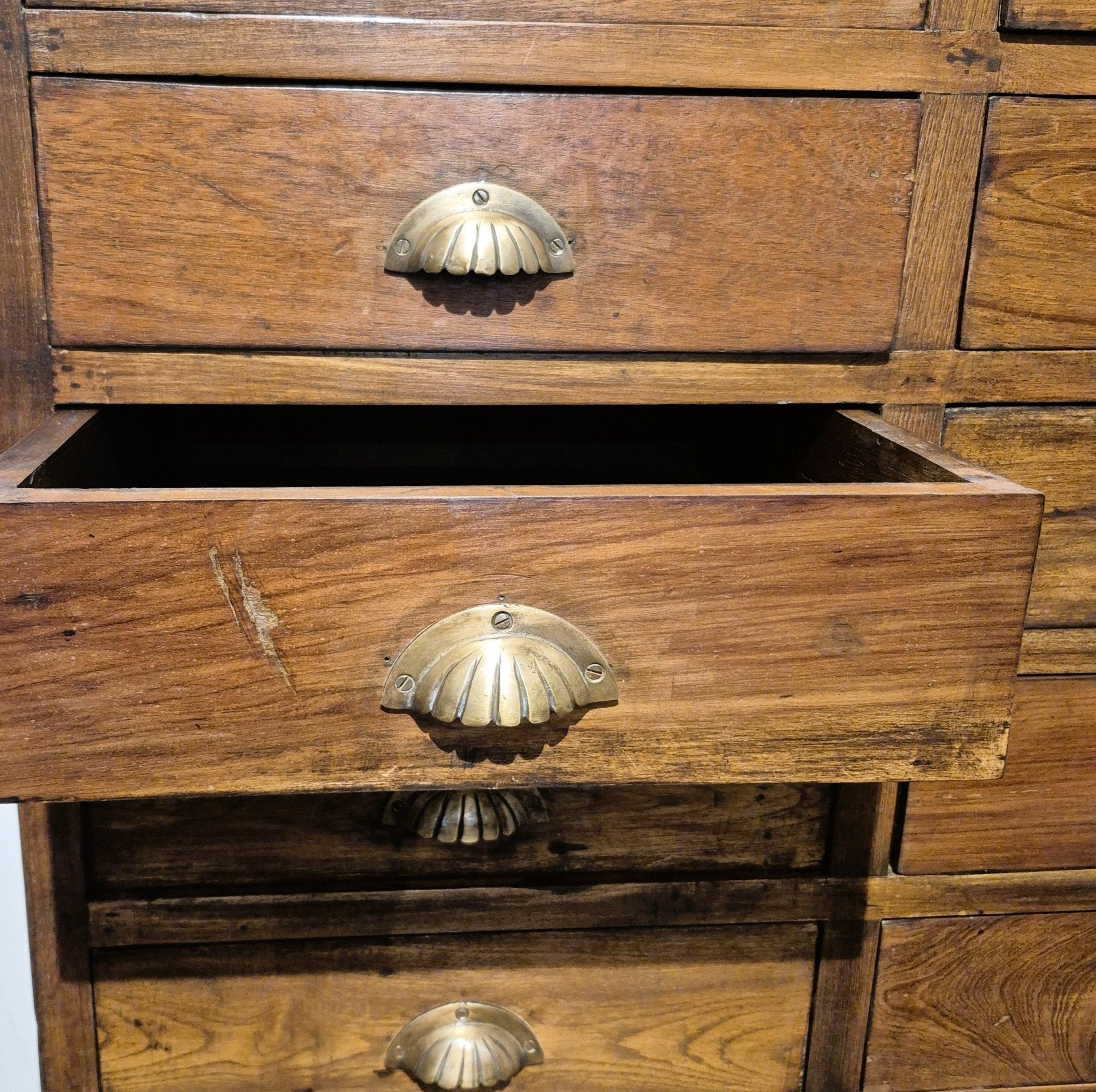 Tall teak bank of twenty two small drawers in a natural wax finish, 41 cm deep, 84 cm wide, made in India