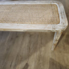 Cane-top bench with fluted legs and a limed finish