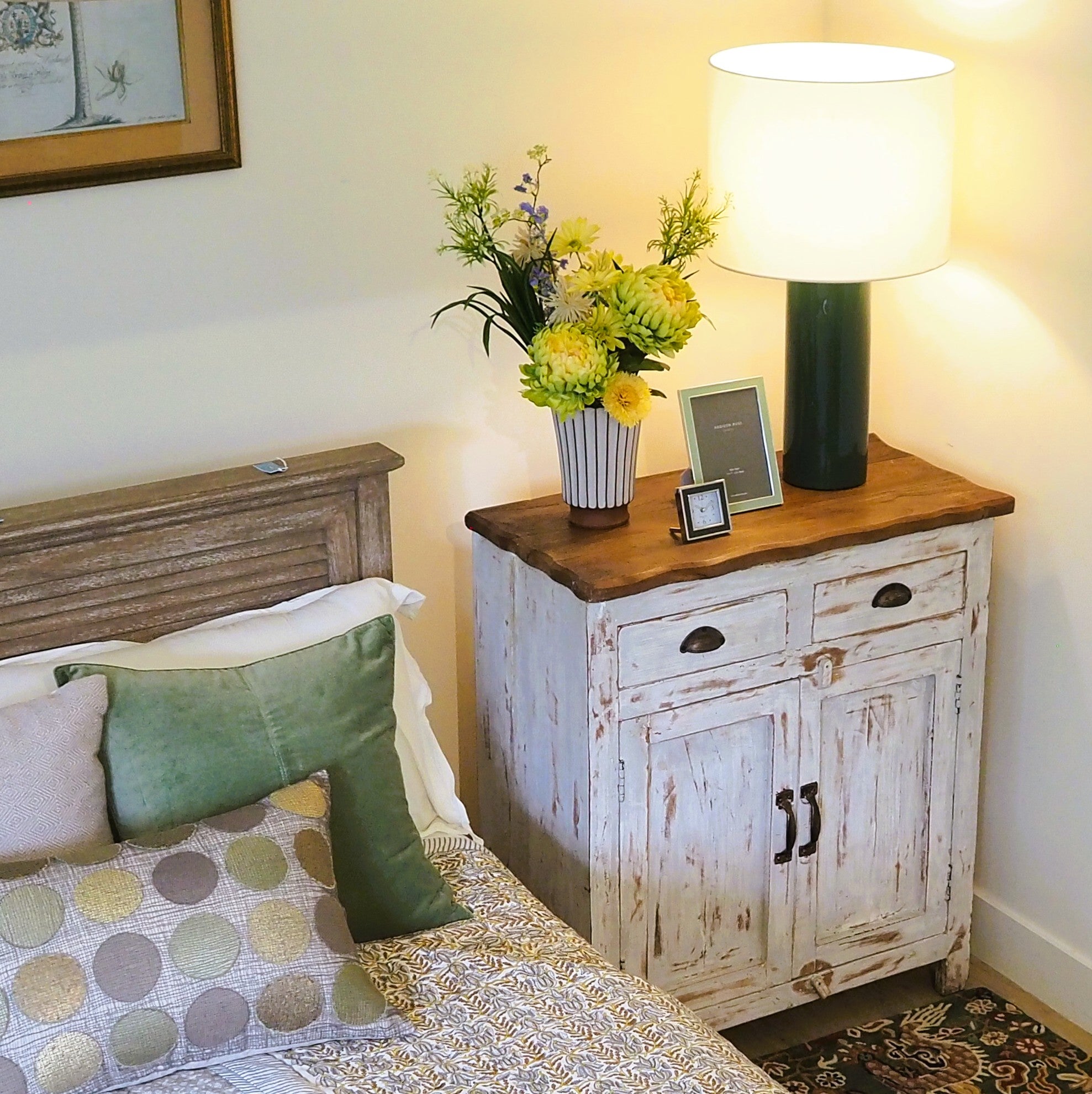 Green lacquer table lamp with white drum shade, styled in a room
