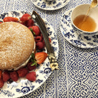 Horn cake knife on a plate with a cake and a cup of tea