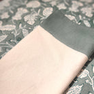 White cotton napkin with a teal block-print border