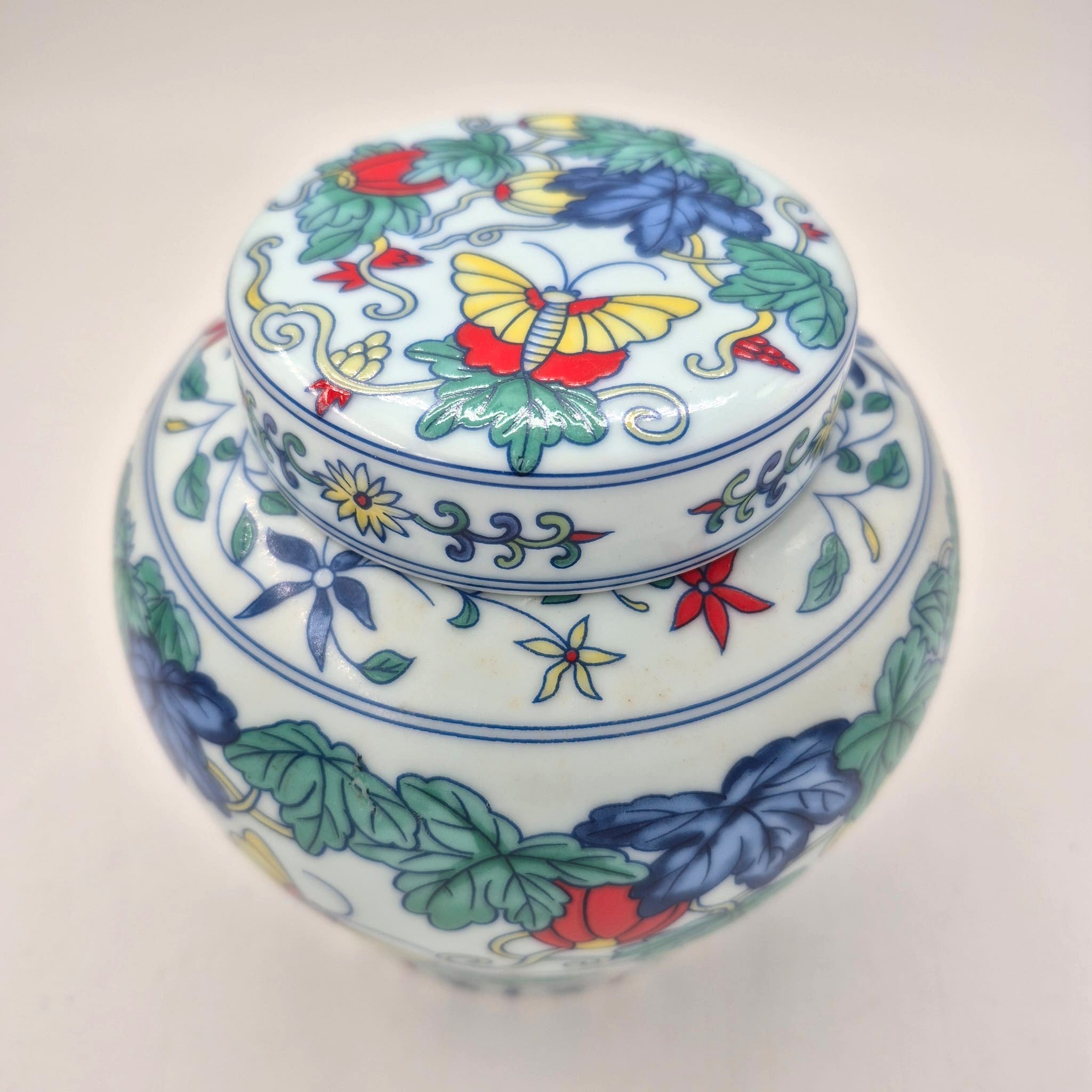 Butterfly Garden candle, classic blue and white lidded pot, styled view