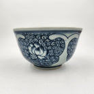 Blue and white ceramic rice bowl with lotus pattern on a white background