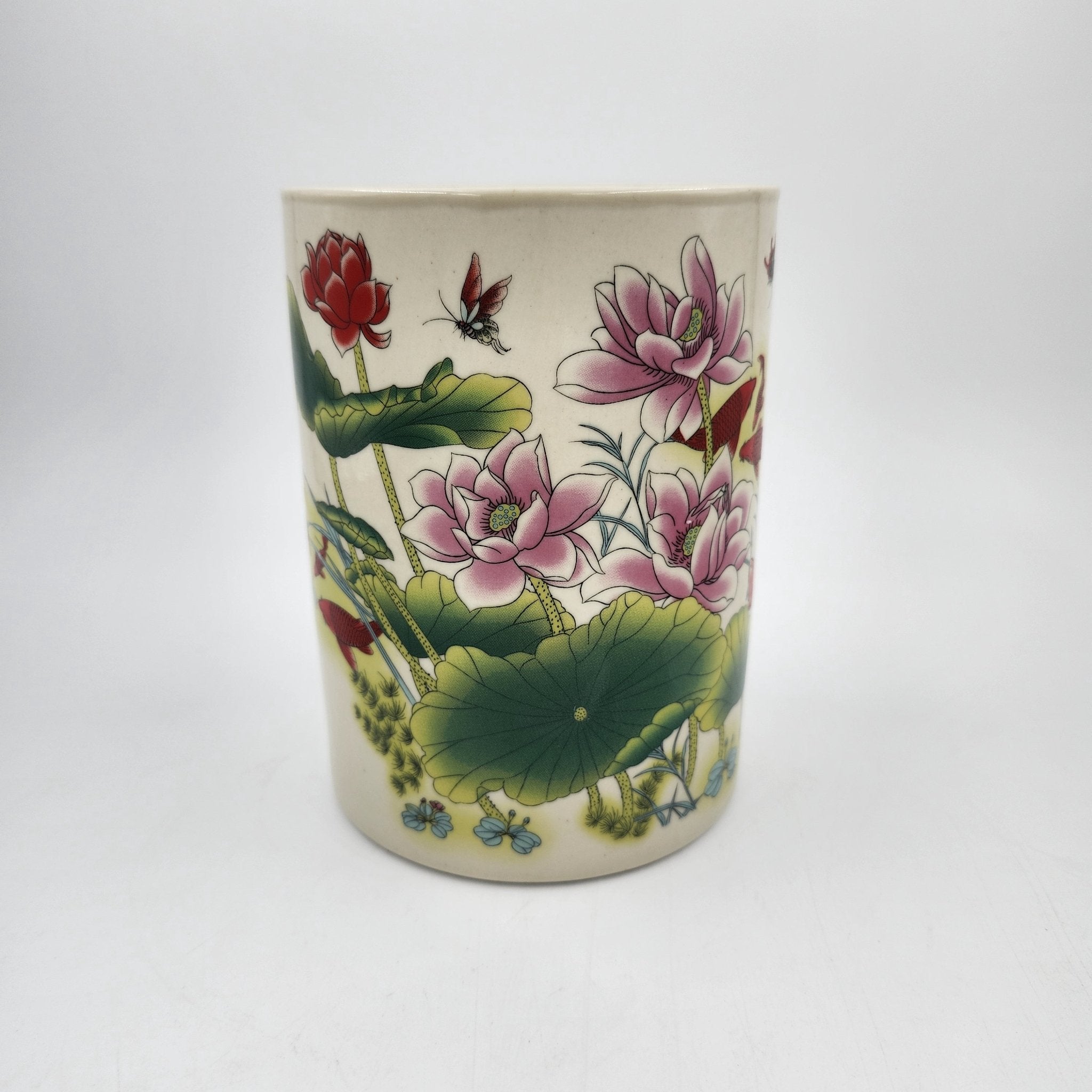 Scented candle in a ceramic jar with lotus design on a white background
