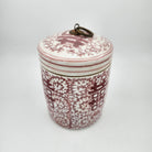 Decorative scented candle with floral pattern in faded red