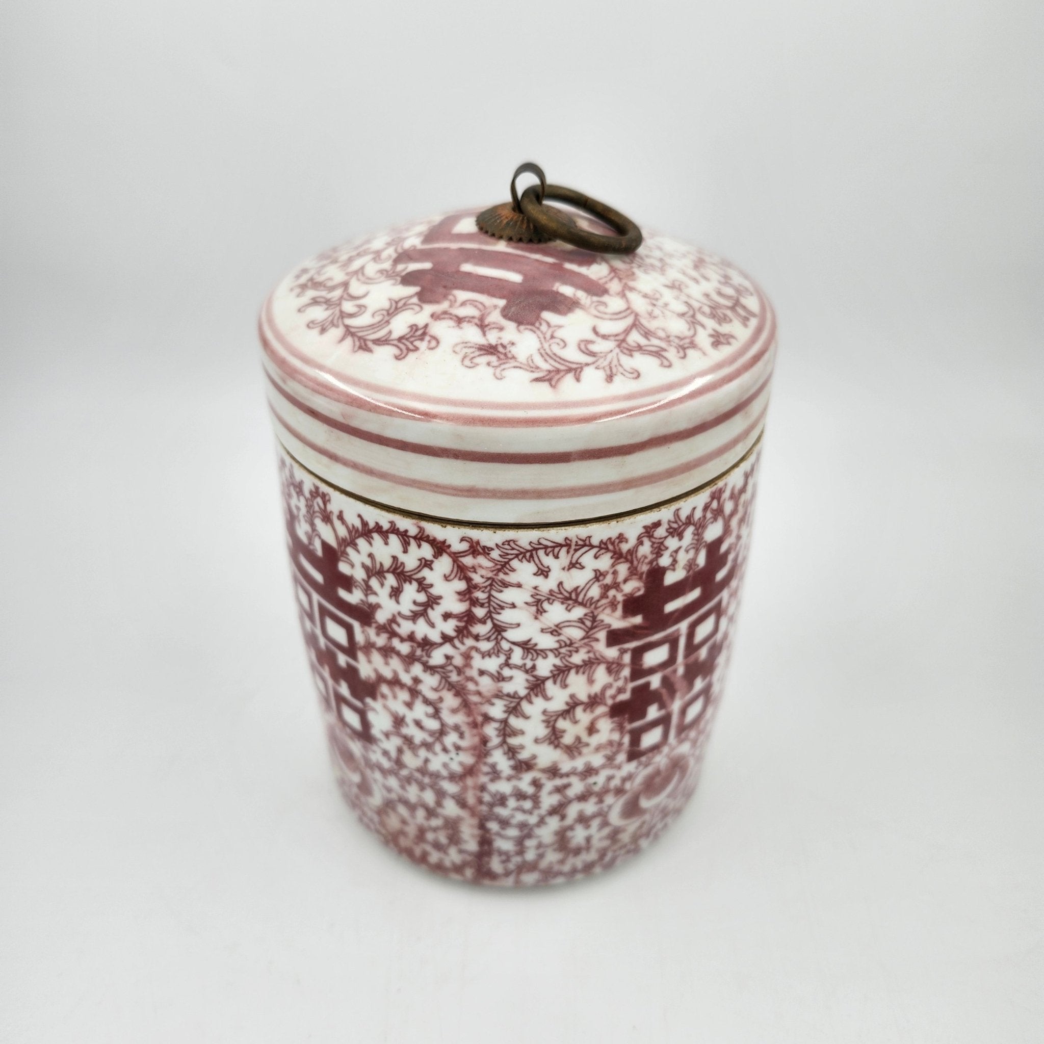 Decorative scented candle with floral pattern in faded red