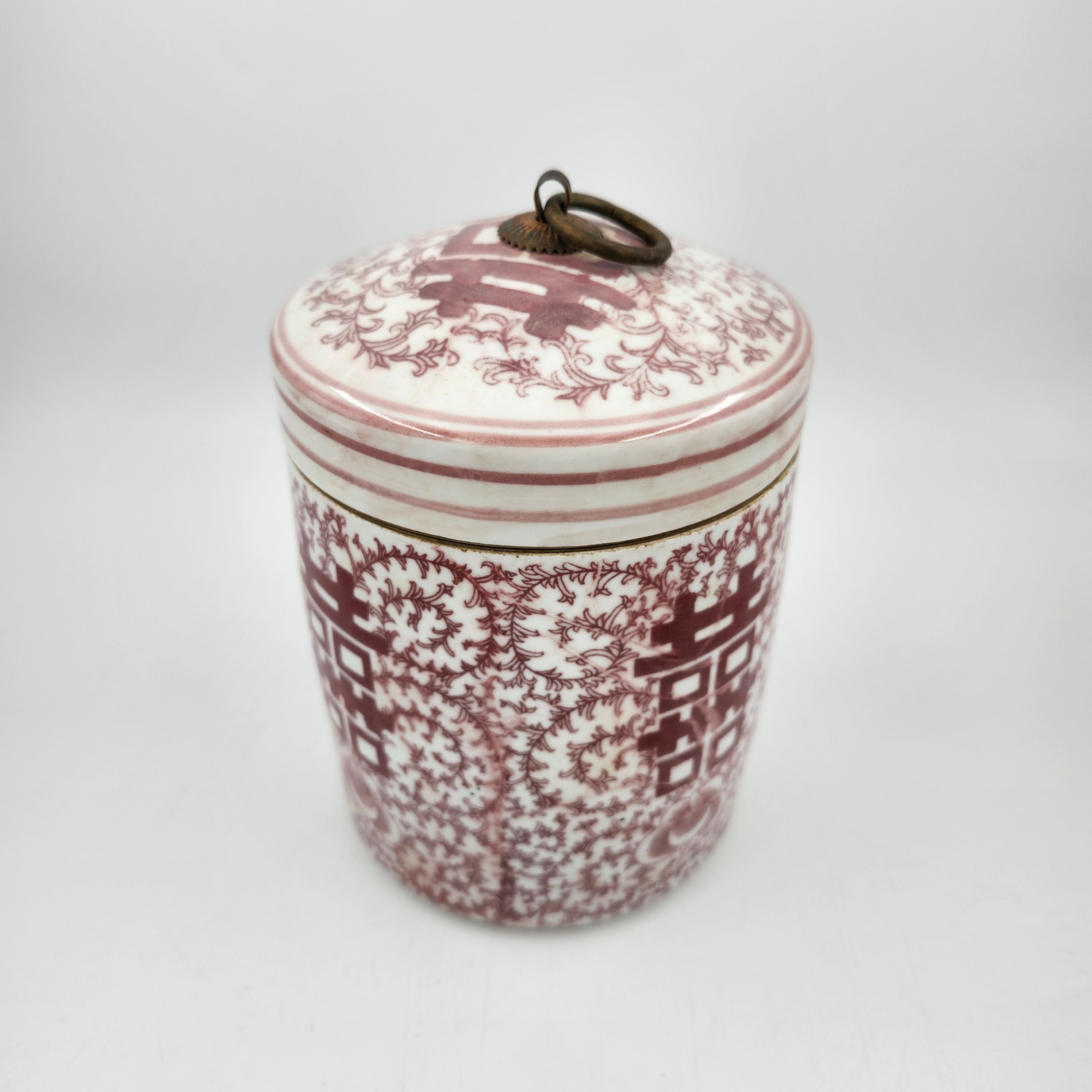 Decorative scented candle with floral pattern in faded red