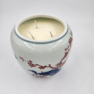 Ceramic candle holder with peacock design on a white background