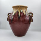 Deep red glazed ceramic lidded pot with two handles, detail
