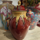 Glazed ceramic lidded vase in deep red with umber collar, two handles, 33.5cm high