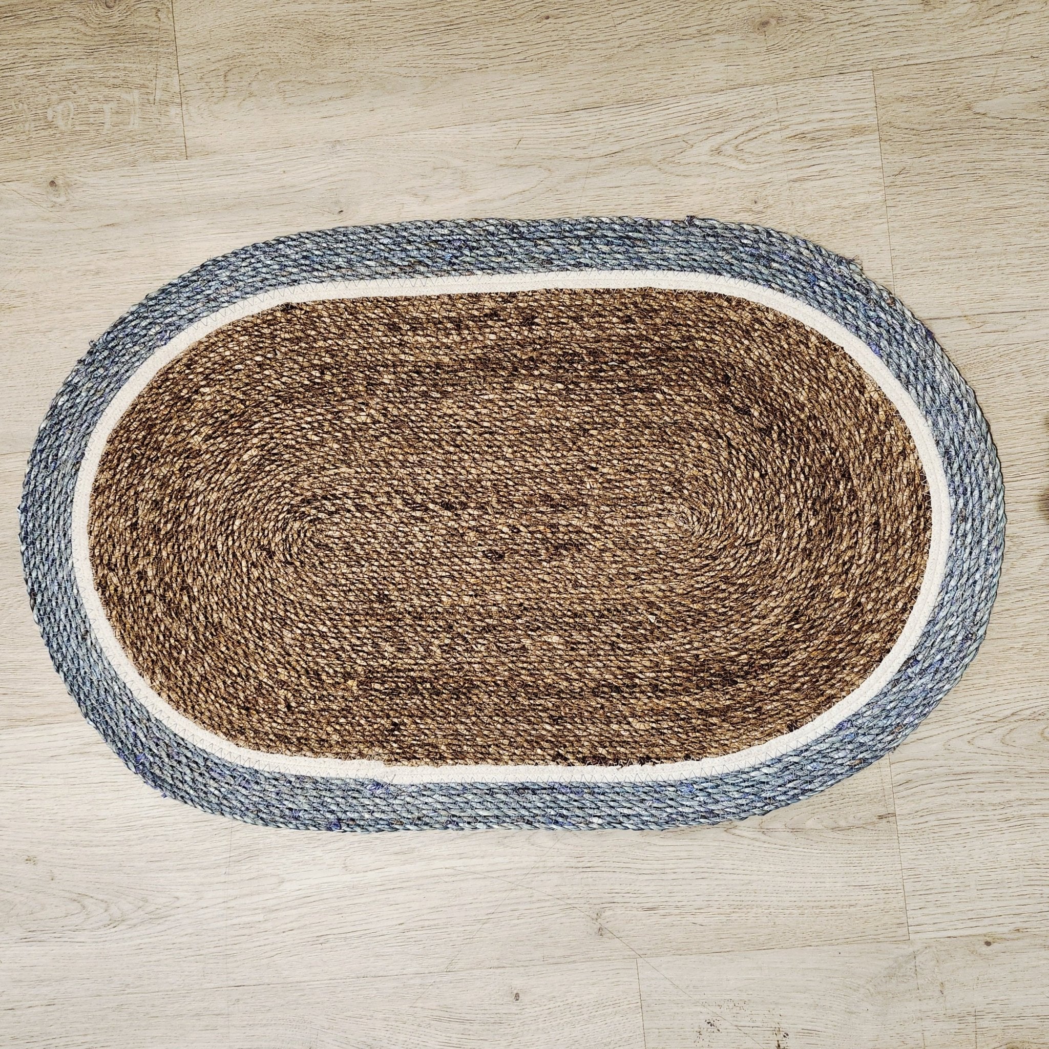 Oval woven jute door mat with brown centre and teal border, 80 x 49 cm
