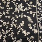 Black pashmina with white embroidered border, draped, styled