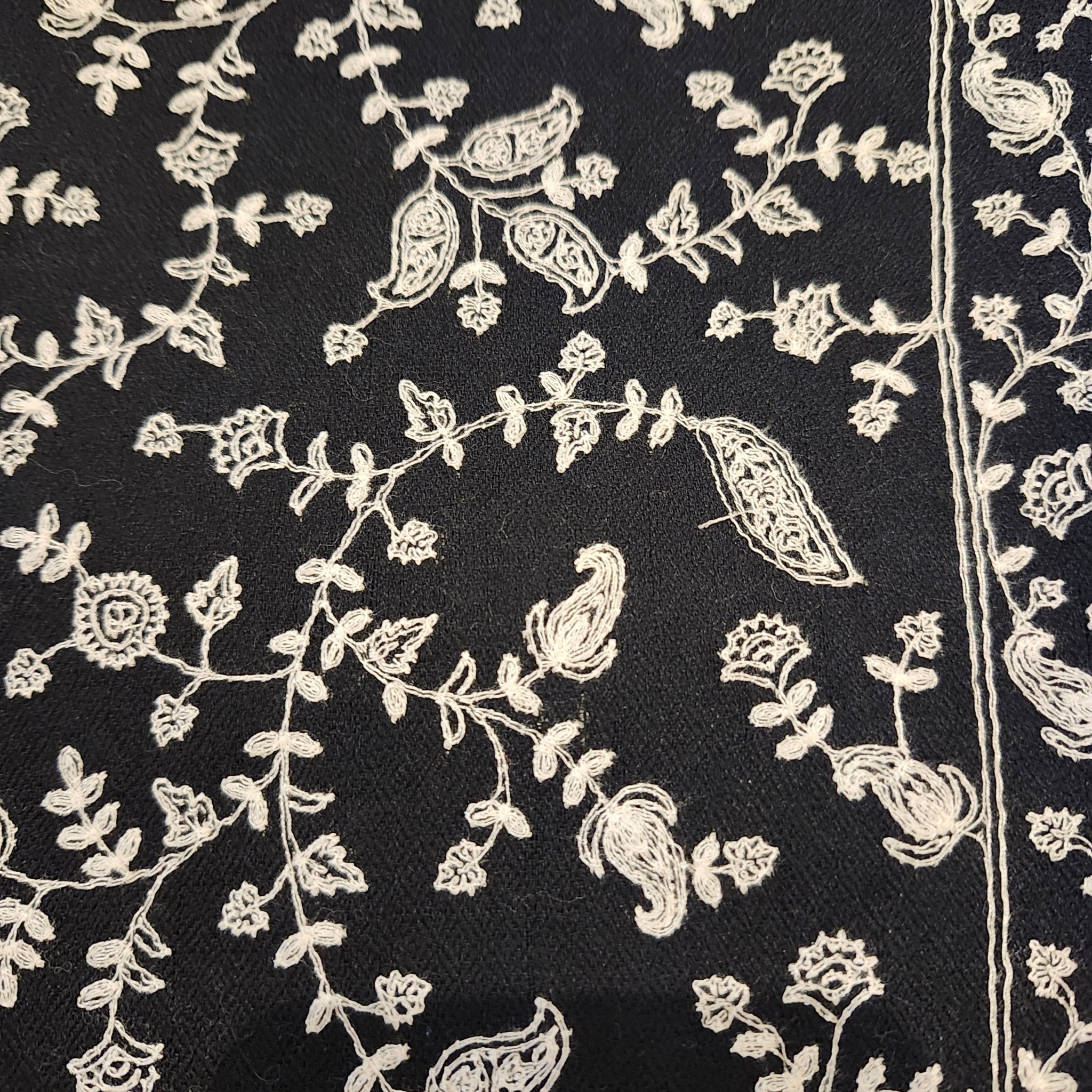 Black pashmina with white embroidered border, draped, styled