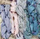 Lightweight cotton scarf with a pompom fringe in pastel shades