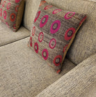 Handwoven O cushion with polka dot pattern styled on a sofa, wool and silk
