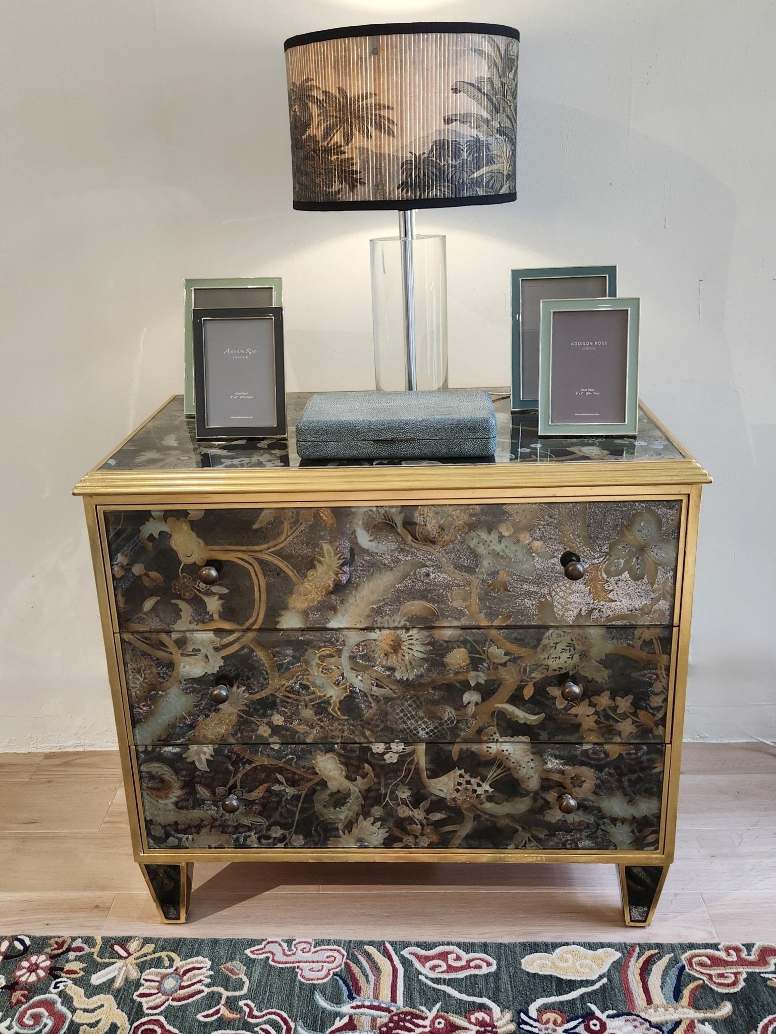 Églomisé chest of drawers detail showing antiqued brass knobs and gilded wood frame, 78.5 x 48 x 72 cm