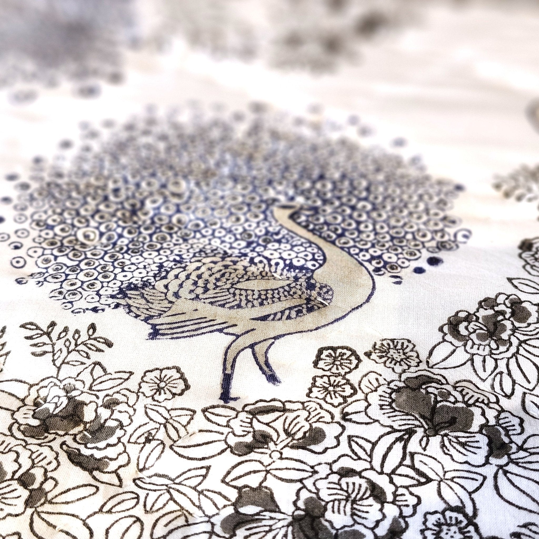 Close-up of blue peacock block print on white voile
