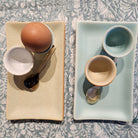 Egg cup sitting on a ceramic tray dish