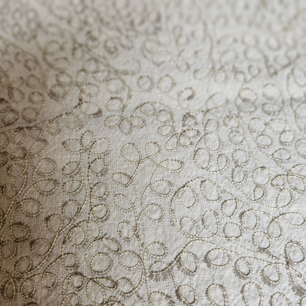 Natural cotton linen table runner machine embroidered with an intricate swirl design, cotton satin reverse.