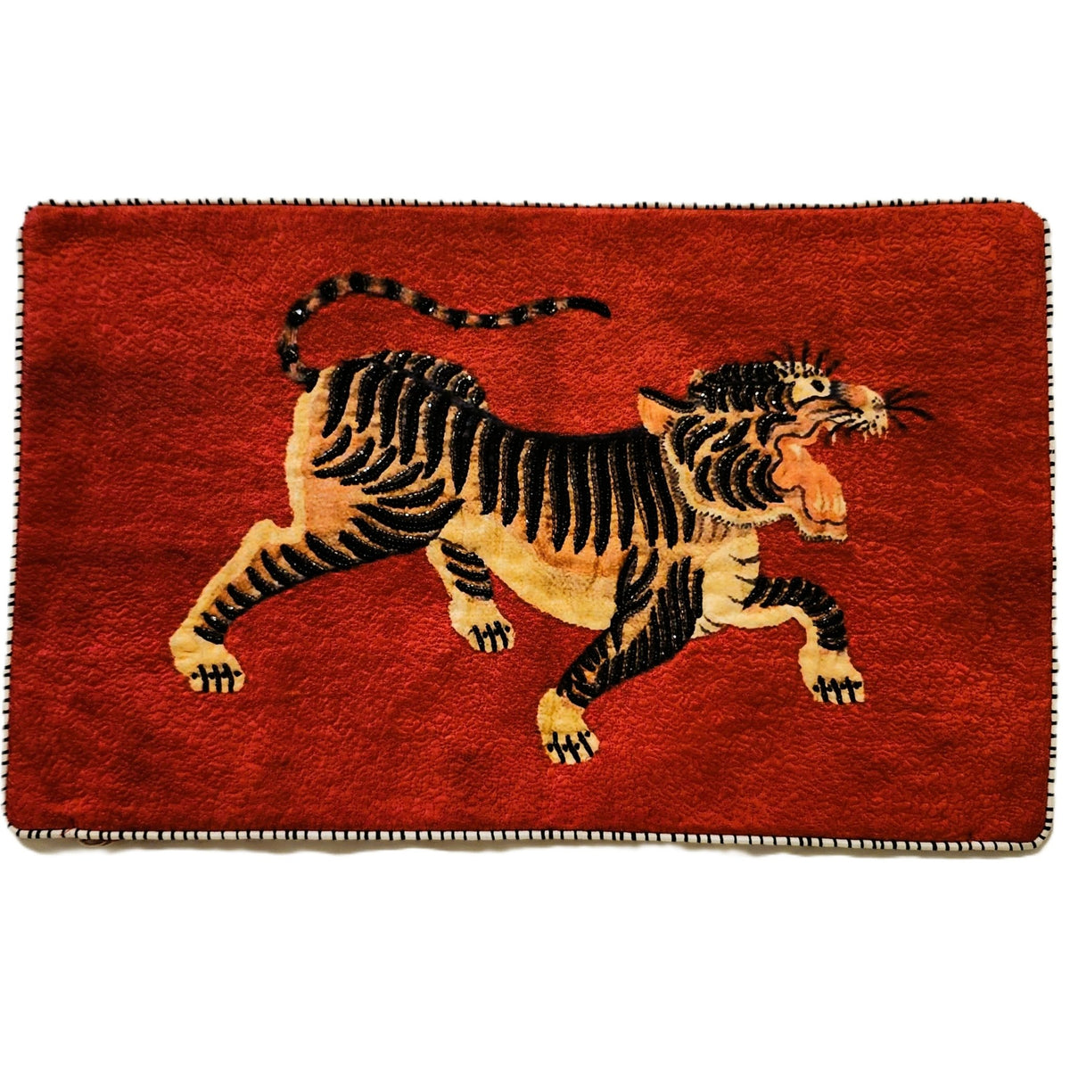 Red silk cushion cover printed with a prancing tiger, beaded and finished with contrast piping, 30 by 50cm.