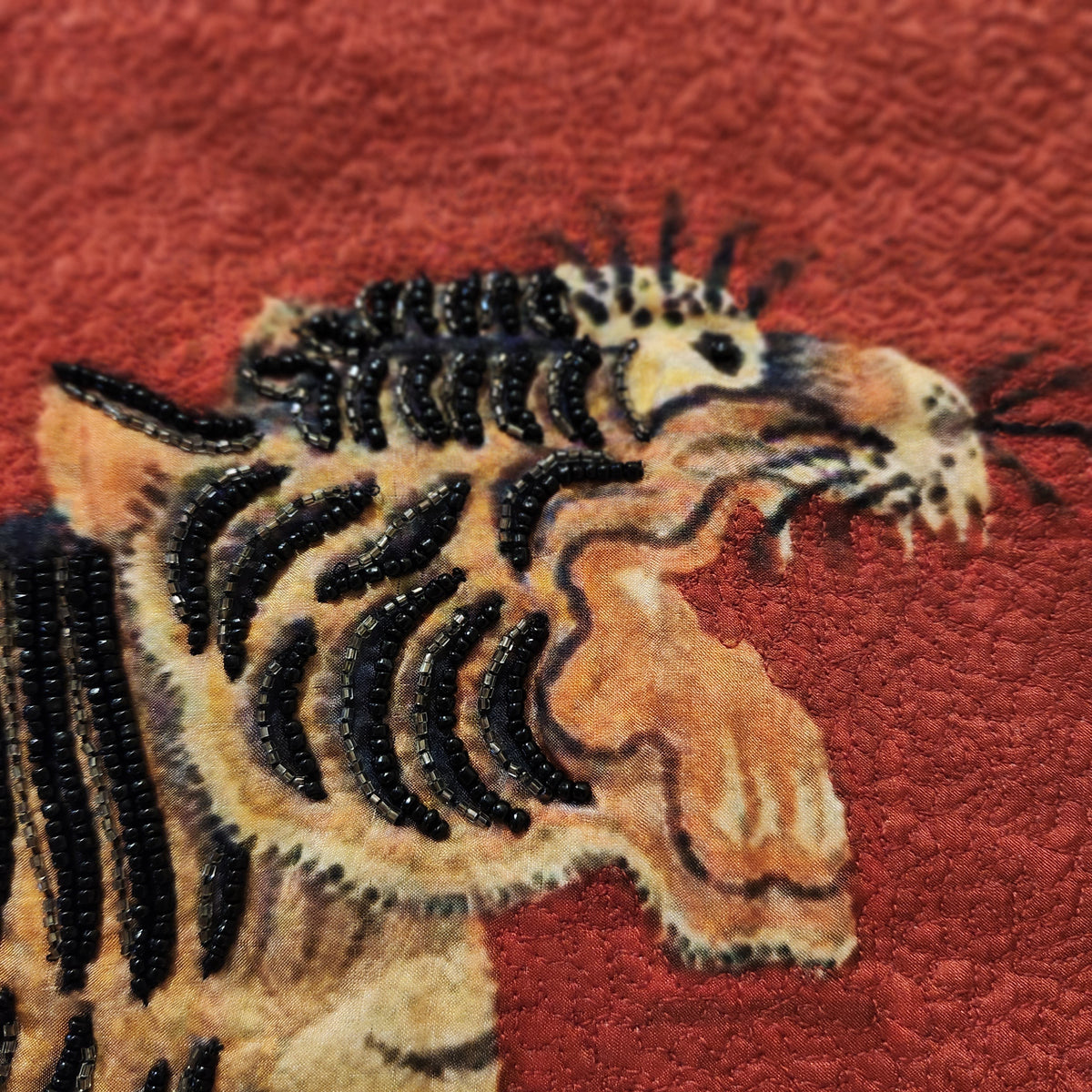 Detail of the beadwork on the prancing tiger cushion, hand crafted in India in 100 per cent silk.