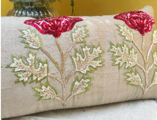 Decorative pillow with floral embroidery and red poppies on a neutral background
