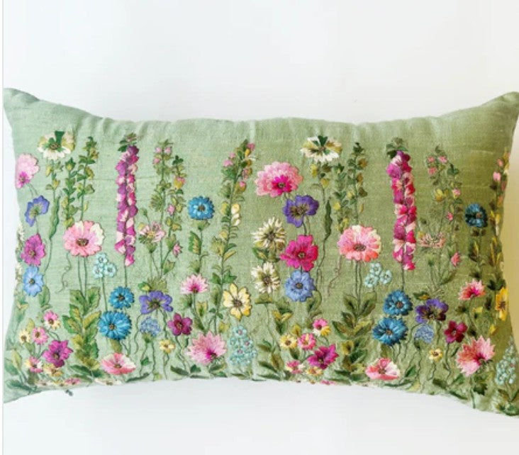 Decorative pillow with floral pattern on a green raw silk background