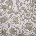 Close-up of embroidered fabric with floral patterns on a cream background