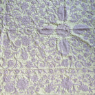 Suzani throw in lavender on pale green cotton, styled as a decorative wall hanging or draped sofa throw
