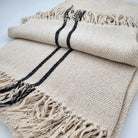 Handwoven cream silk throw with black parallel line edges and fringing, 130 x 200 cm