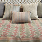 Hand embroidered cushion with shell pink stripes grouped with other cushions on a Zig Zag Vintage Kantha