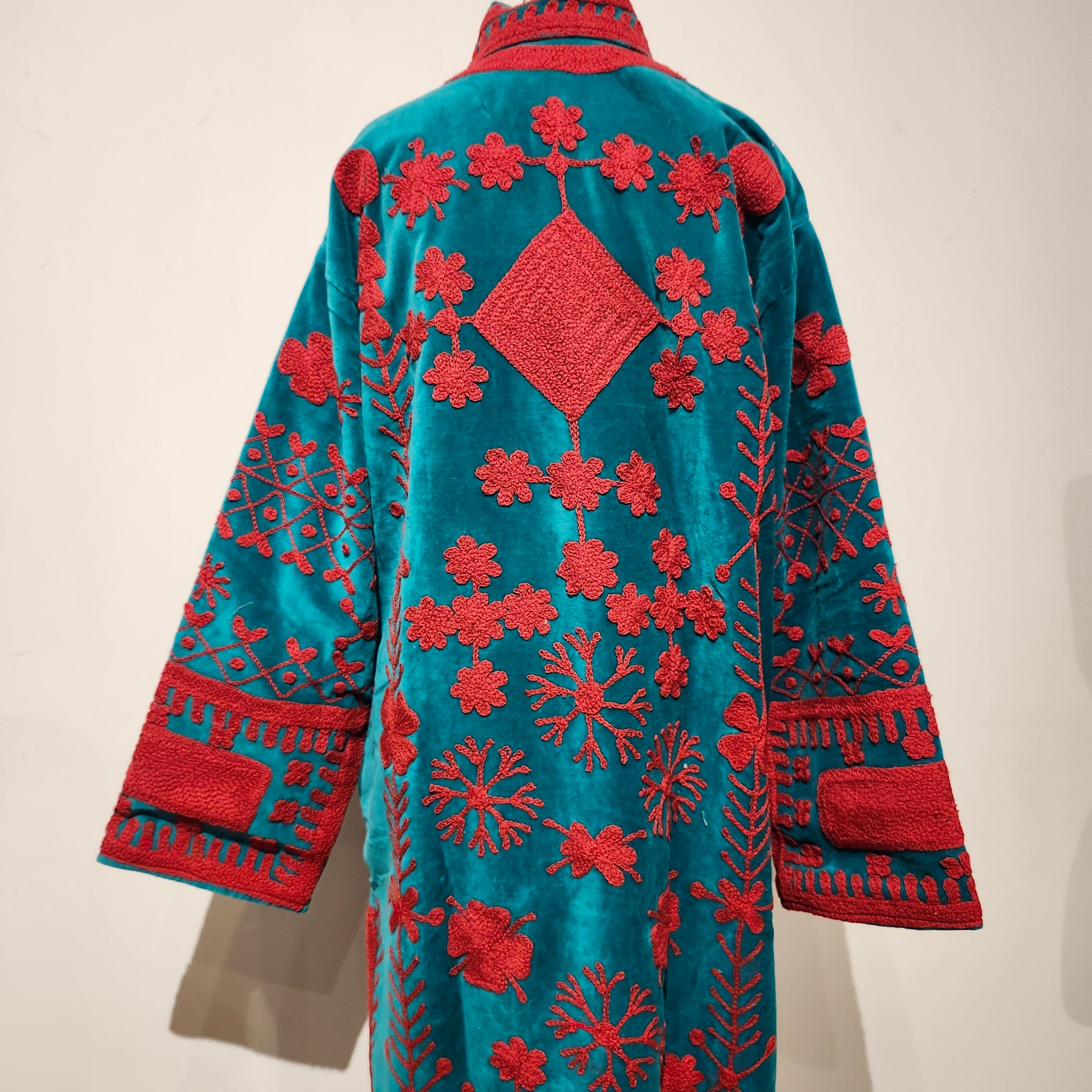 Turquoise velvet coat with cerise suzani stitching, striped cotton lining