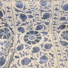 Suzani fabric with blue pomegranate pattern on cream background