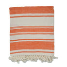 Striped orange and white towel with fringe on a white background