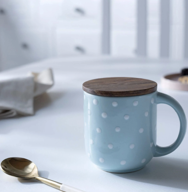 Blue polka-dot ceramic mug with a wooden lid coaster
