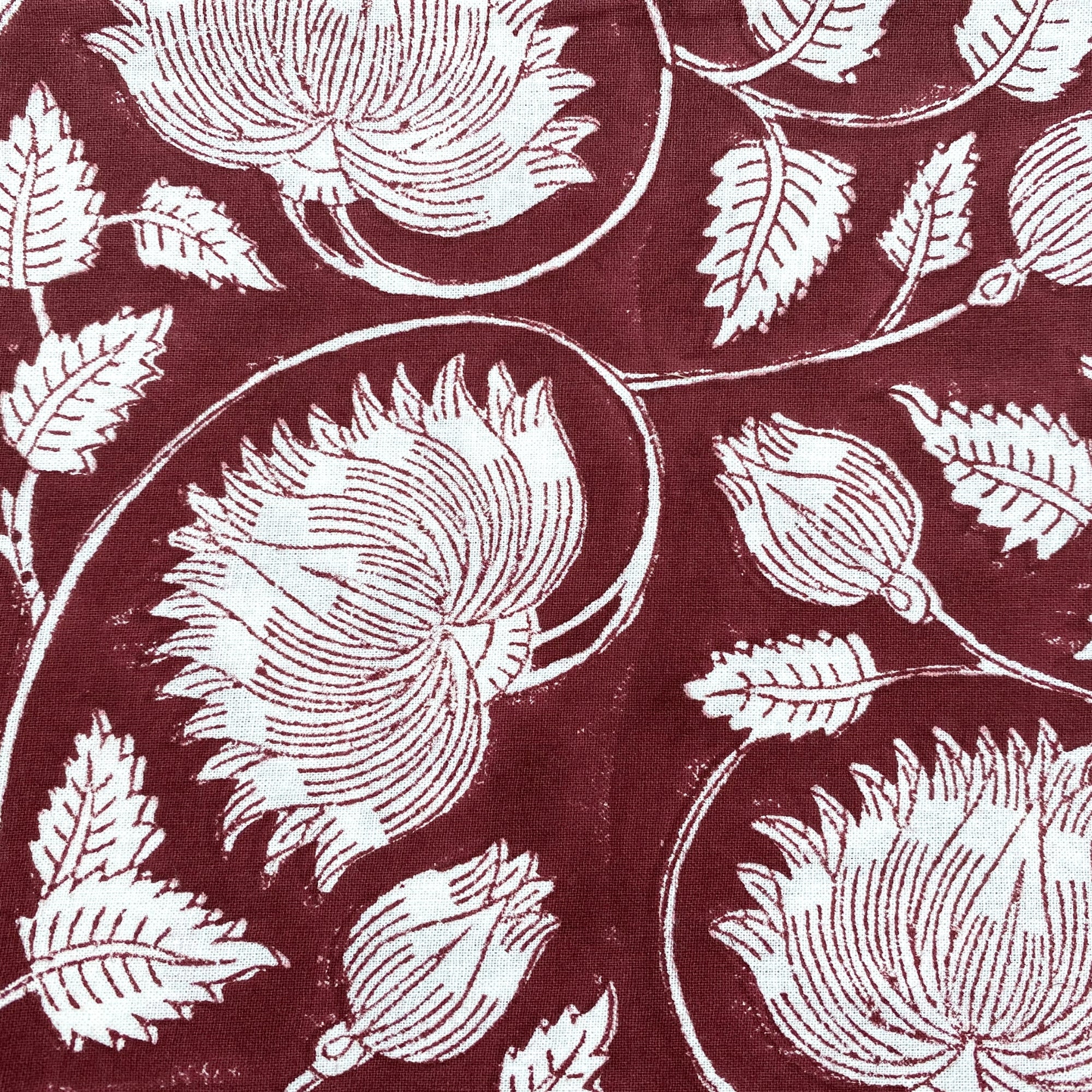 Burgundy lotus block-print cotton tablecloth with floral motifs and neatly striped edges