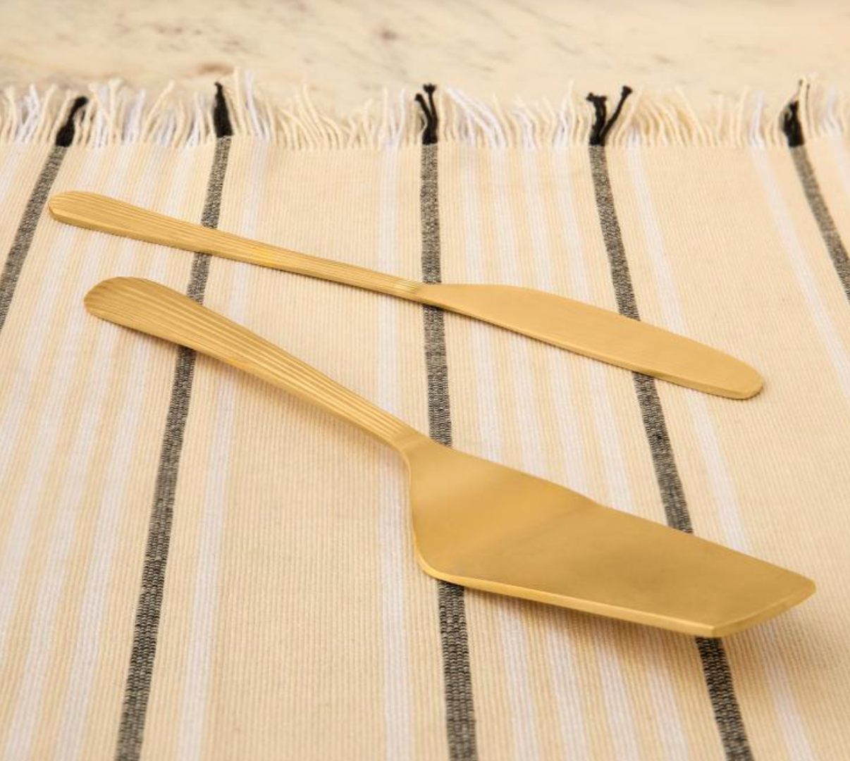 Brass cake server set with a matte gold finish