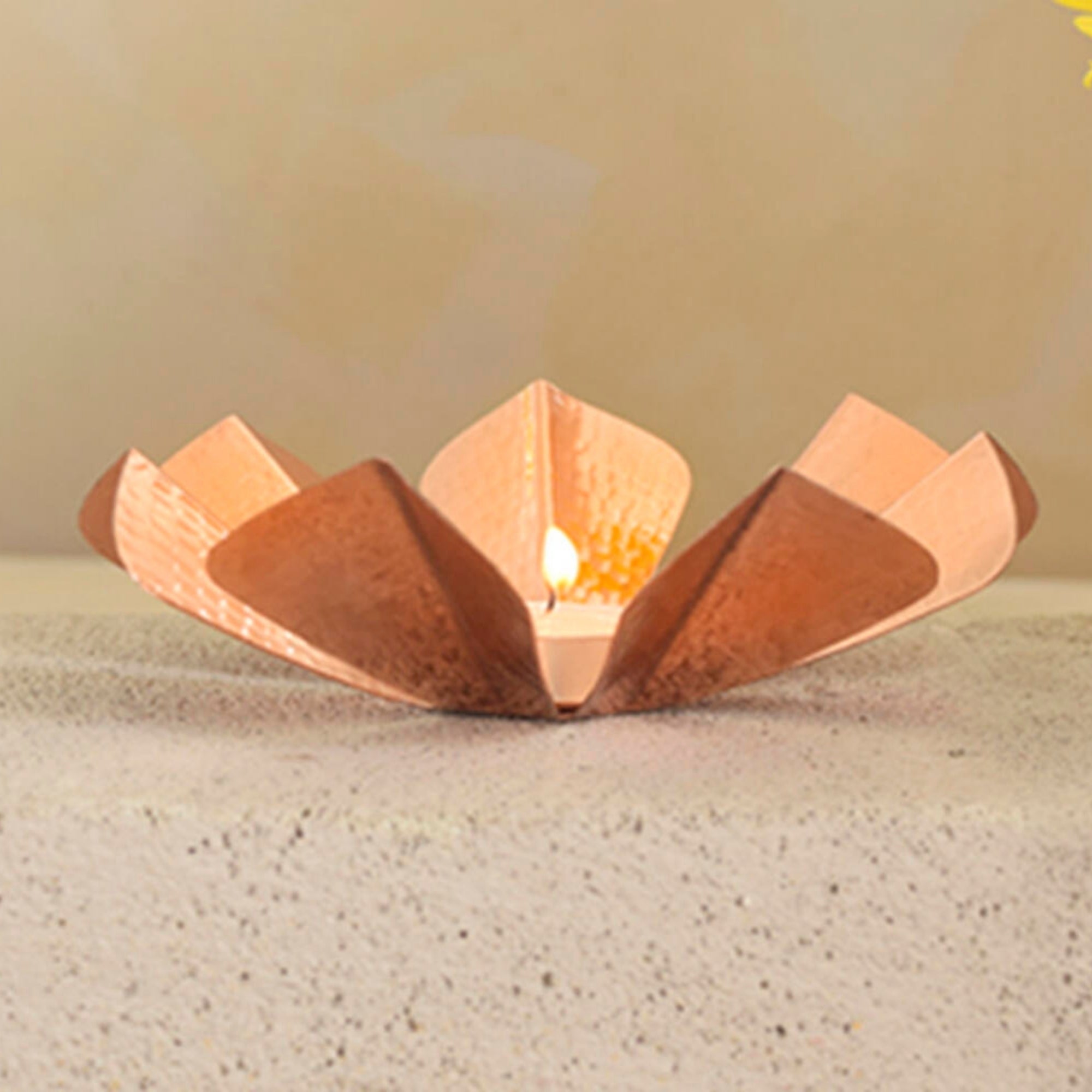 Hand-beaten copper flower-shaped tea light holder, handmade in India
