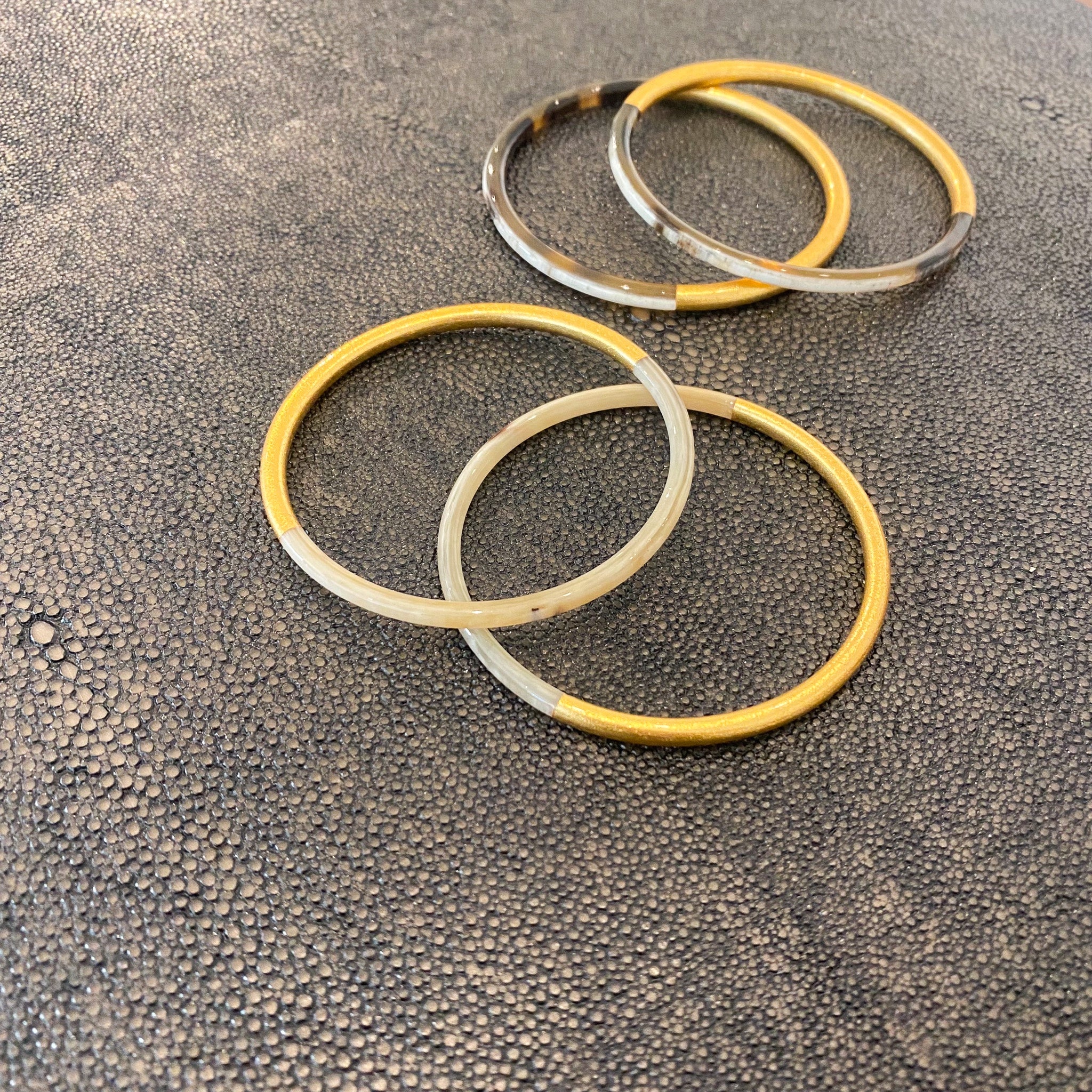 Horn bangle with gold finish, worn as a pair, detail view