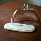 Oval marble-based glass cloche by Ellementry, styled on a table